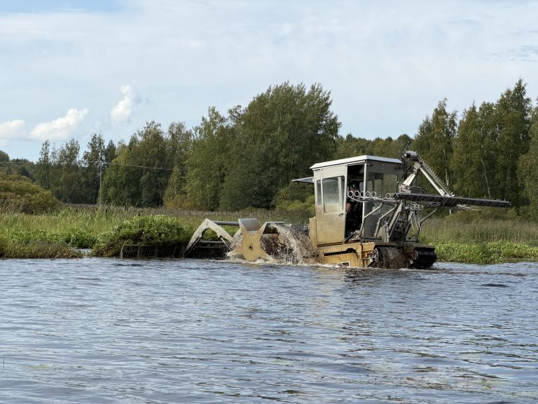 Kaimaani 5000 irroittamassa vesijättöä jokisuussa. Näin saadaan vesi virtaamaan paremmin joessa. Kohde oli Lintumaalla, Pirkanmaalla.